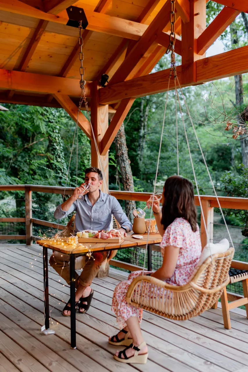Deux personnes dînent sur une terrasse en bois - Cabane spa Occitanie - Dolce et Cabane
