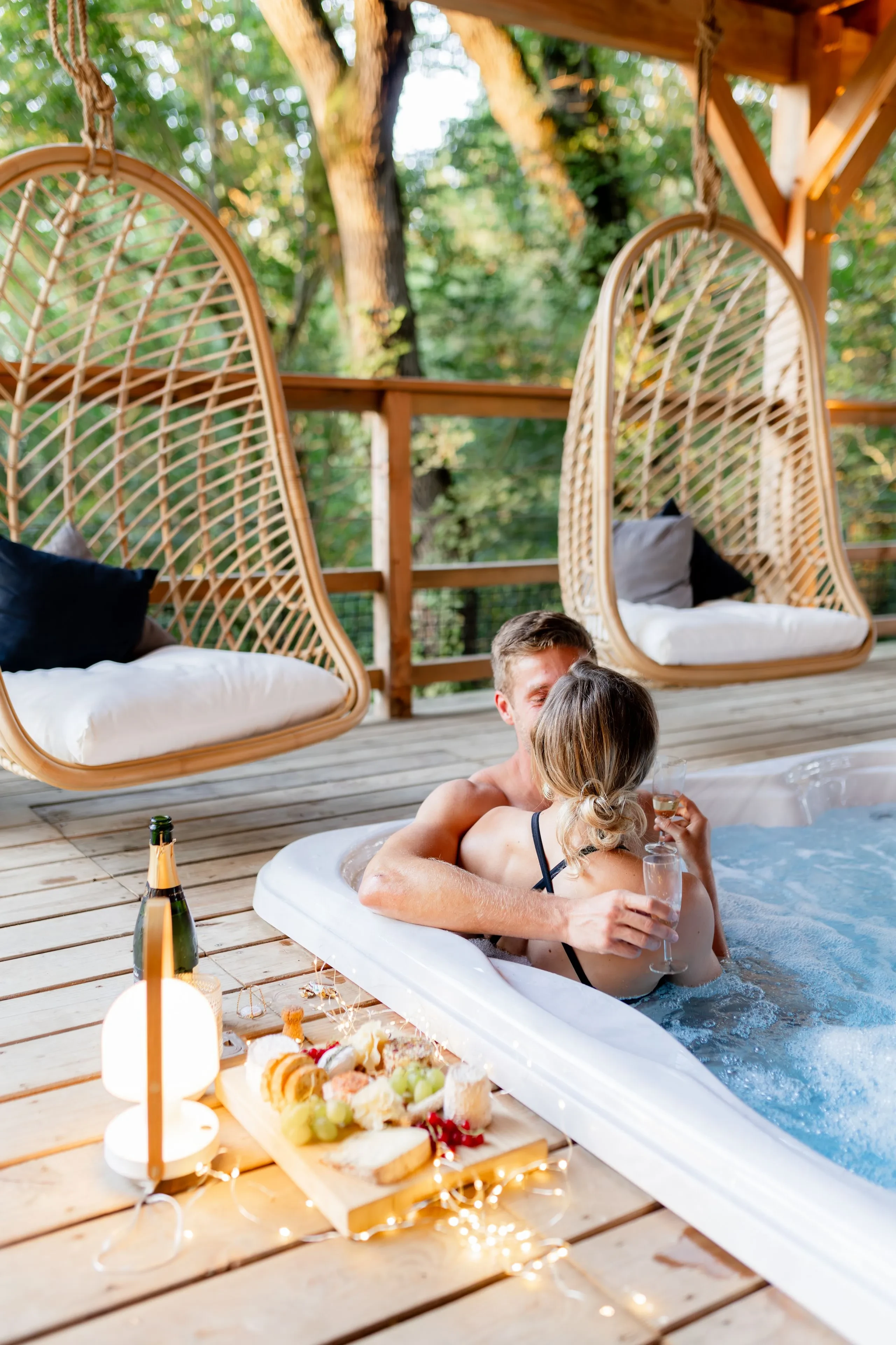 Couple relaxant dans un jacuzzi avec boissons.