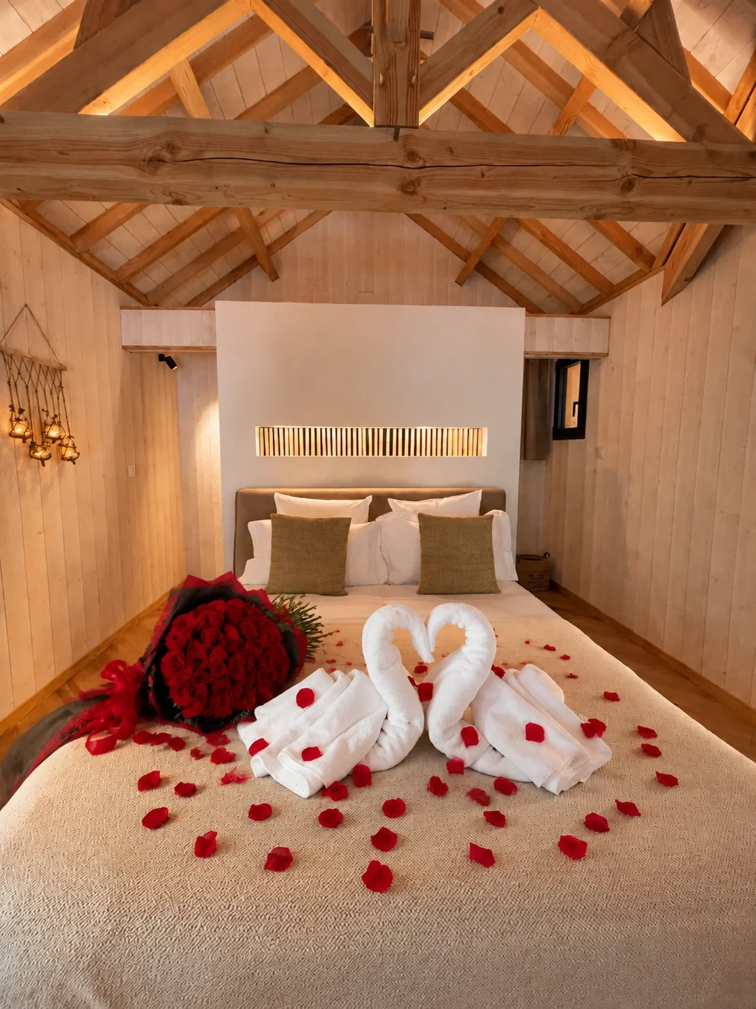 Chambre romantique avec cygnes en serviettes et roses rouges